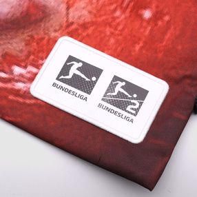 Auf eine Tasche aus altem Bannermaterial ist ein Schild genäht, das das Bundesliga-Logo zeigt.